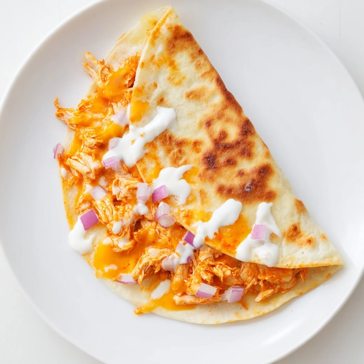 Golden-brown Buffalo Chicken Quesadilla with a cheesy interior, served alongside cool ranch dressing.