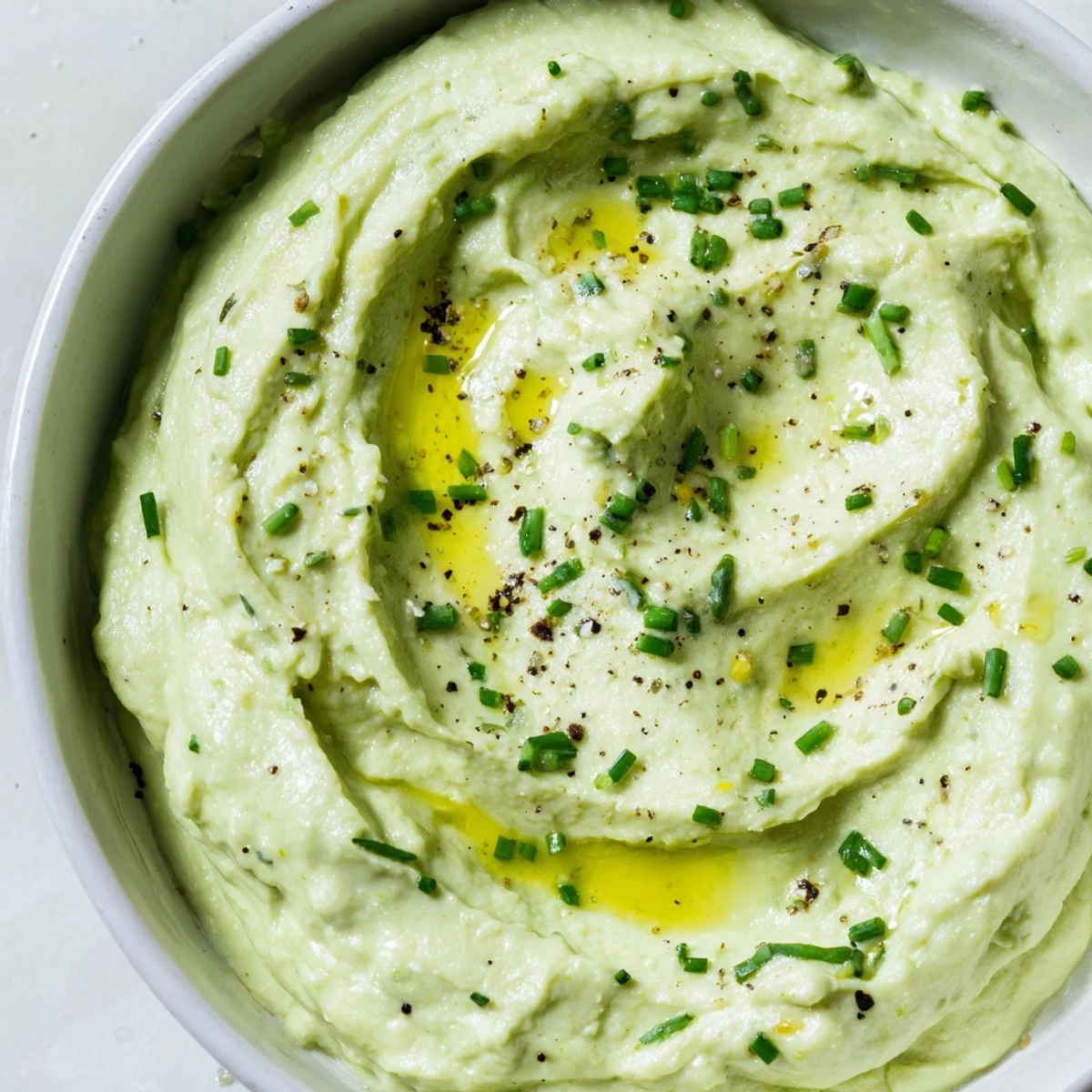 Fresh chives garnish a bowl of Avocado Cottage Cheese Dip, a healthy and delicious appetizer option.