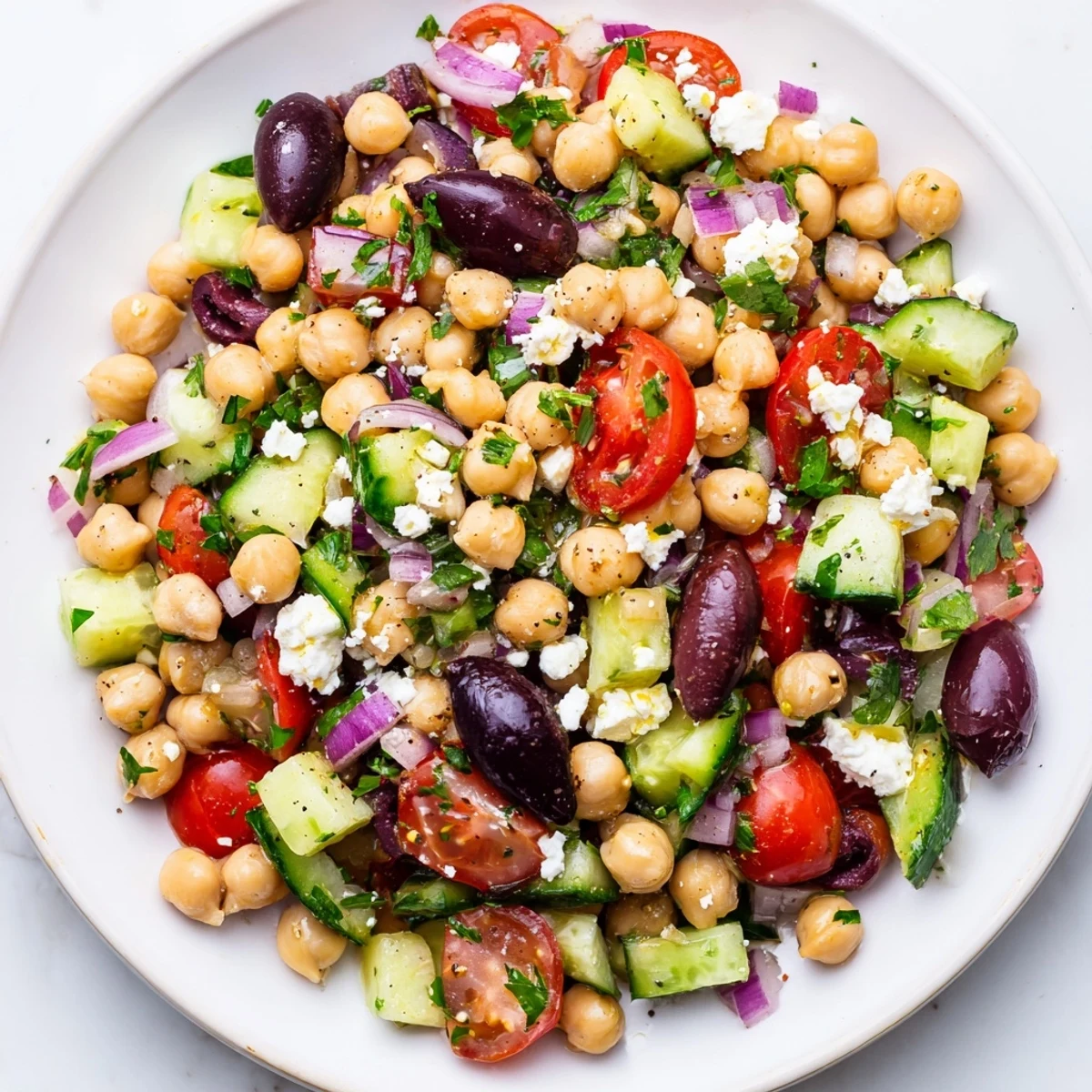 Vibrant Mediterranean Chickpea Salad, bursting with fresh veggies and creamy feta, drizzled with zesty lemon dressing.