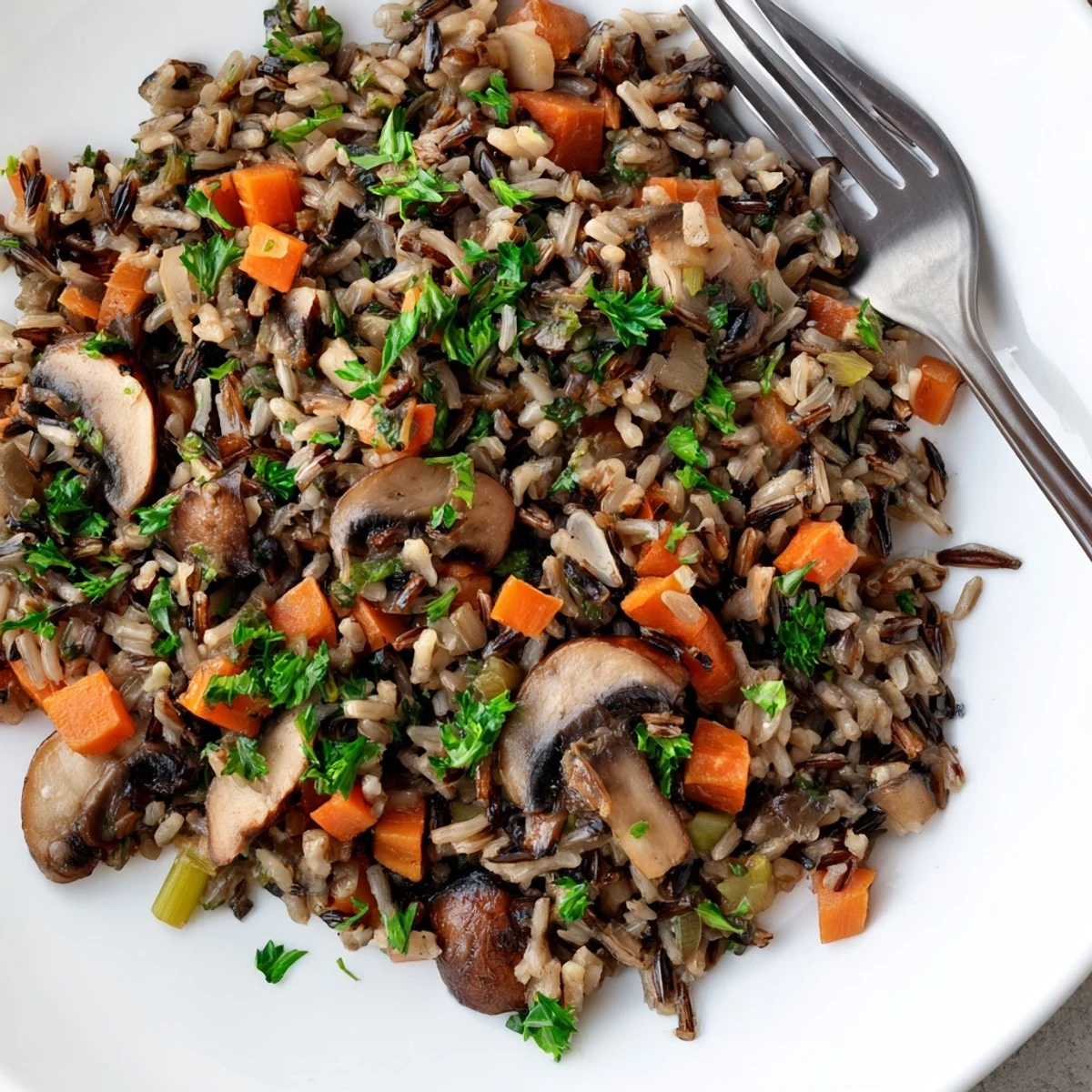 Golden sautéed mushrooms and tender wild rice pilaf with carrots, celery, and thyme, showcasing a hearty, earthy side dish ready to serve alongside roasted poultry.