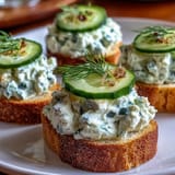 Elegant Derby Day Benedictine Cucumber Canapés, a refreshing appetizer adorned with cucumber.