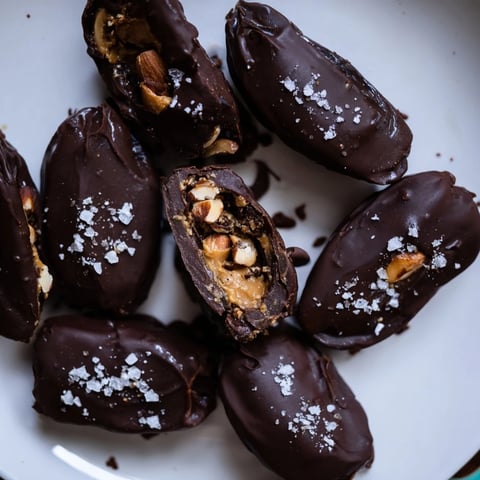 Dark chocolate-covered Chocolate Date Snickers with a peanut butter filling and salty sea salt sprinkle.