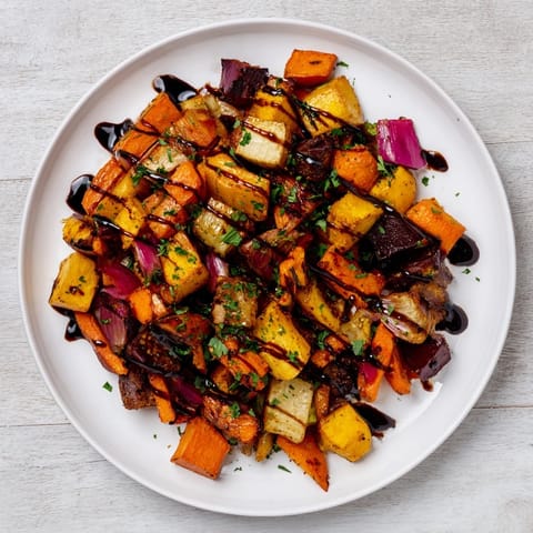 Oven-roasted root vegetable medley glistening with balsamic glaze, a colorful and savory side dish.