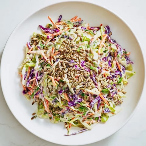 Creamy crunchy coleslaw salad topped with sunflower seeds, a delicious side dish.