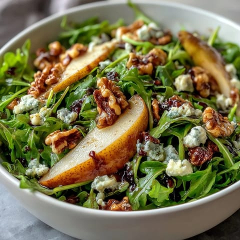 Fresh arugula and sliced ripe pears topped with creamy blue cheese and crunchy toasted walnuts in an Arugula and Pear Bowl.
