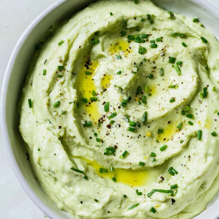 Fresh chives garnish a bowl of Avocado Cottage Cheese Dip, a healthy and delicious appetizer option.
