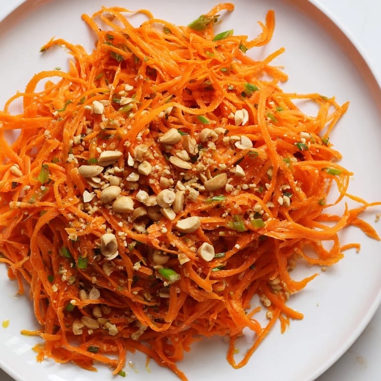 A close-up of Spicy Carrot Salad showcases crunchy carrots with a flavorful Asian-inspired dressing.
