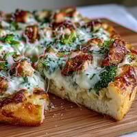 Garlic Parmesan Chicken & Broccoli Pizza with golden crust and bubbling mozzarella on a wooden table.