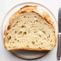 Fluffy, golden-brown loaf of The Best Easy No-Knead Bread, ready to be sliced and enjoyed.